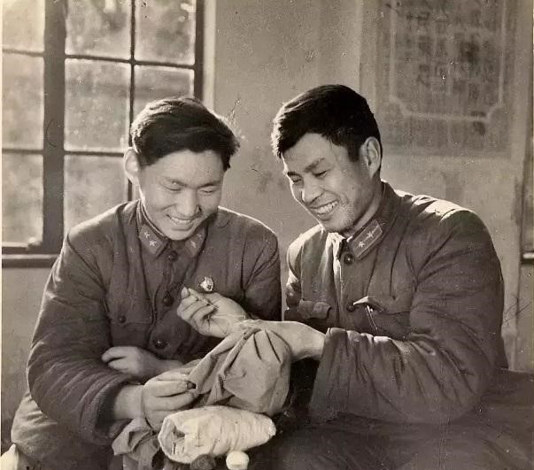 △八连指导员王经文(右)在教战士缝补衣服 △八连指导员王经文(右)在教战士缝补衣服